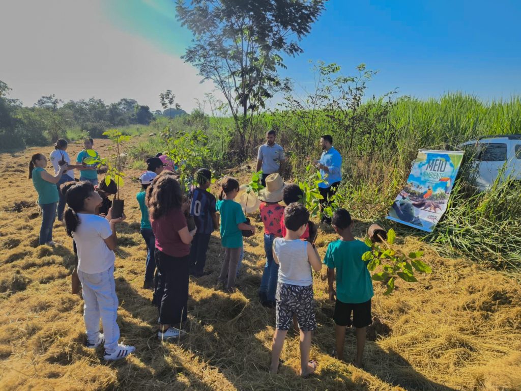 Crianças do Projeto Recrearte realizando plantio de mudas em ação da Usina Caeté